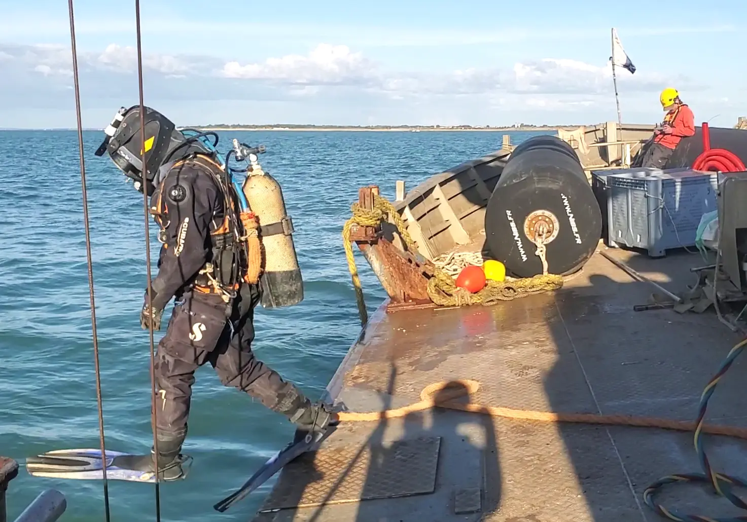 A surface-supplied diver getting into the water to inspect the works