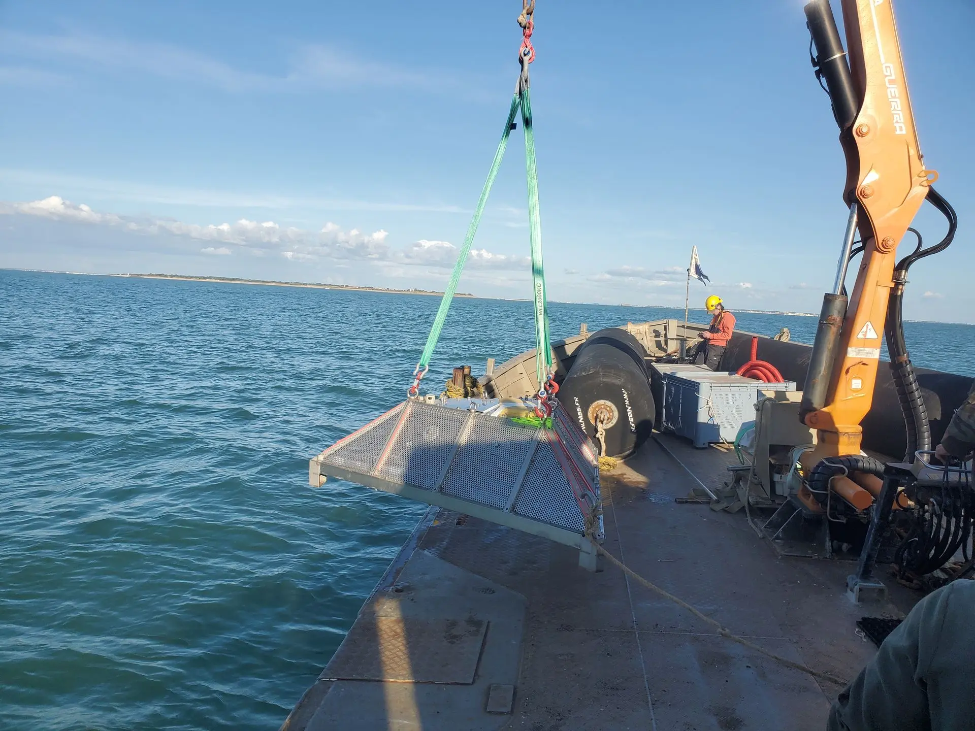 A crane lifting an ADCP with its frame to put it into the water